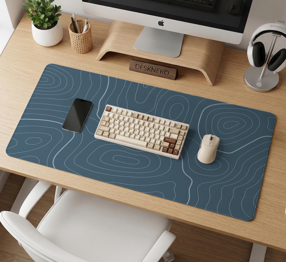 A slate blue desk mat with thin contour line map art on a light background.