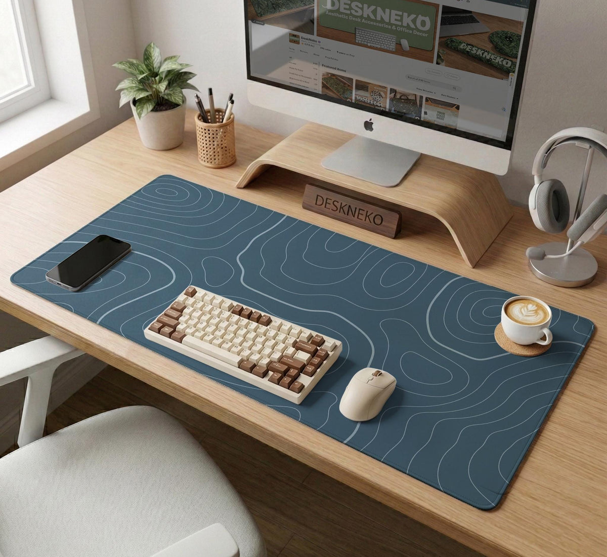 A slate blue desk mat with thin contour line map art on a light background.