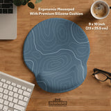 Blue mousepad with a topographic line pattern on a slate background.