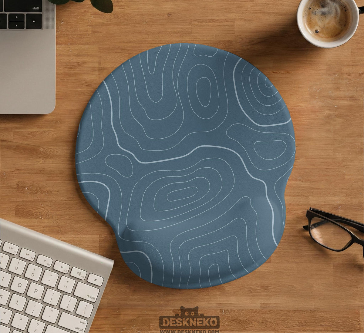 Muted blue desk mat with thin topographic line art pattern shown with matching mousepad and keyboard wrist rest options.