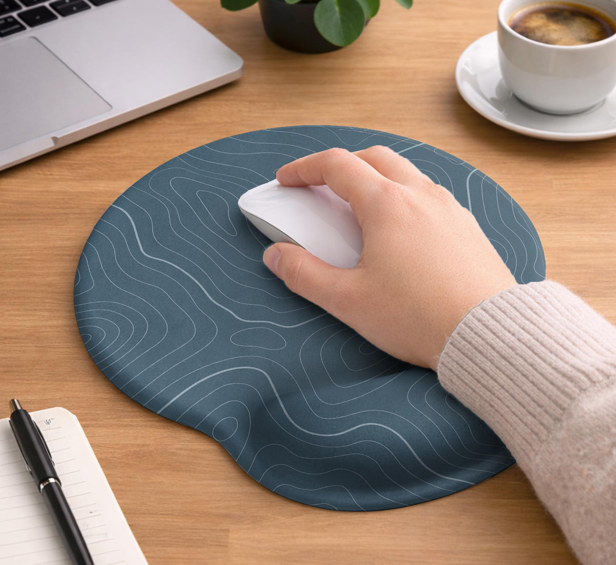 Muted blue desk mat with thin topographic line art pattern shown with matching mousepad and keyboard wrist rest options.