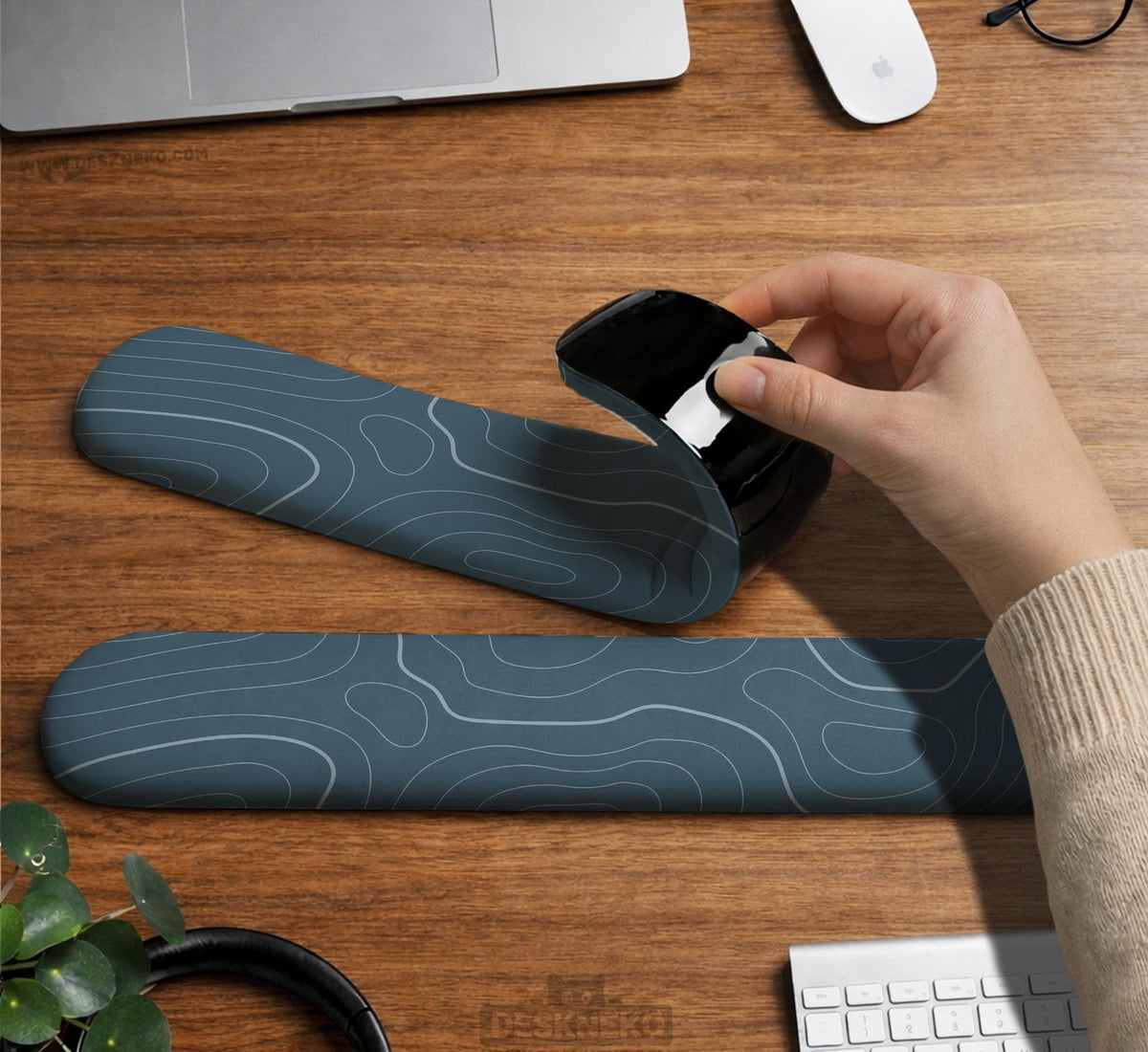 Muted blue desk mat with thin topographic line art pattern shown with matching mousepad and keyboard wrist rest options.