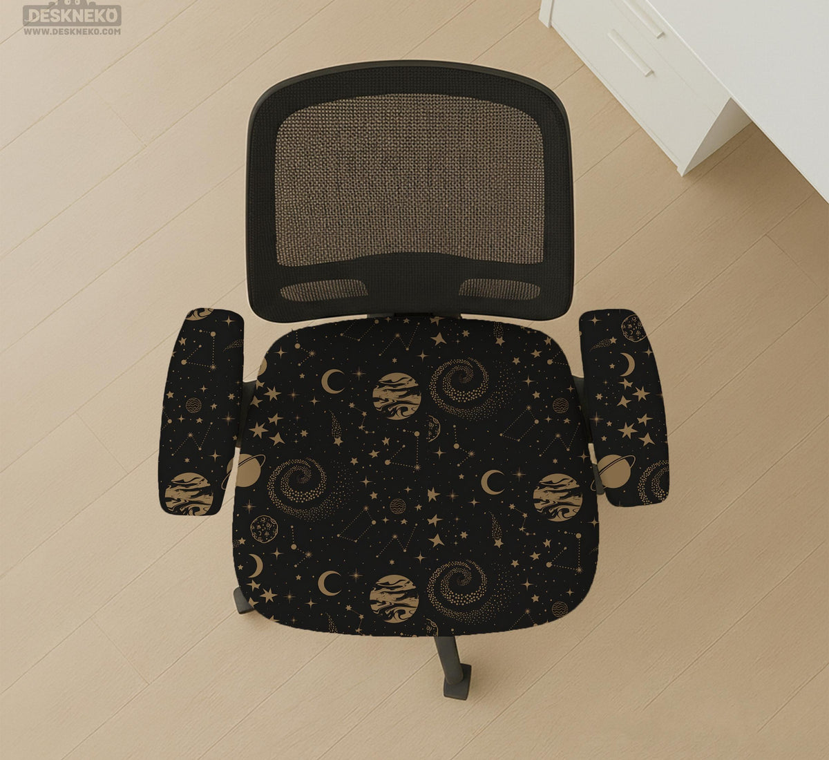 Black chair cover with a dark galaxy pattern, muted gold stars and celestial artwork on a chair.