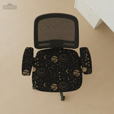 Black chair cover with a dark galaxy pattern, muted gold stars and celestial artwork on a chair.