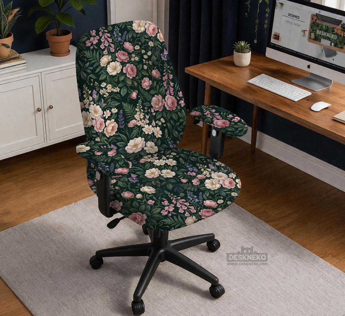 Green chair cover with a dark floral pattern, pink roses, cream flowers, and leafy botanical details on an office chair.