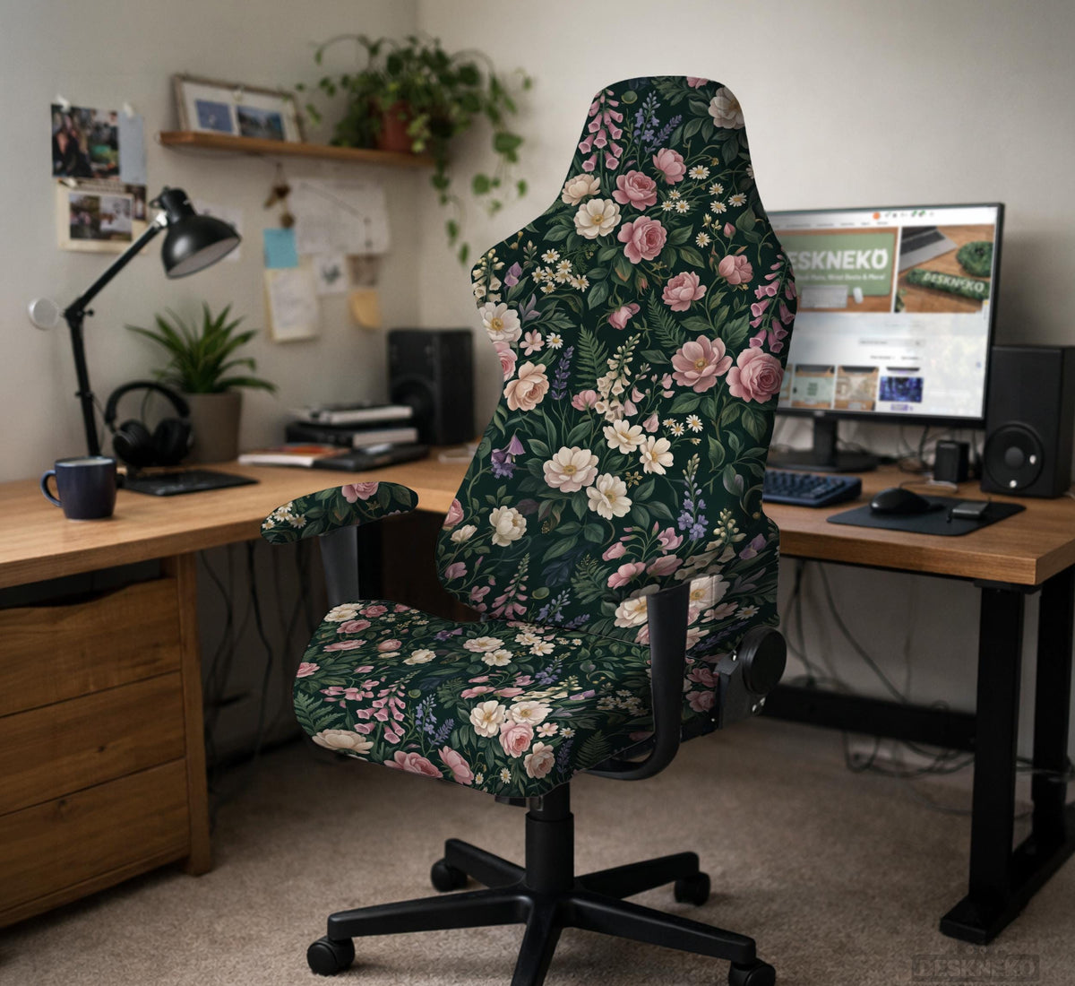 Green chair cover with a dark floral pattern, pink roses, cream flowers, and leafy botanical details on an office chair.