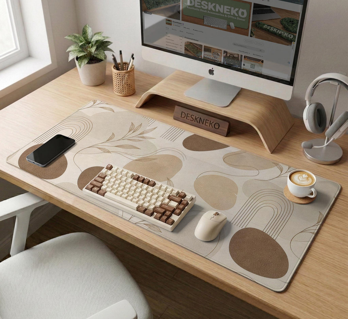 Beige desk mat with fine botanical line drawings and soft abstract shapes on a light neutral background.
