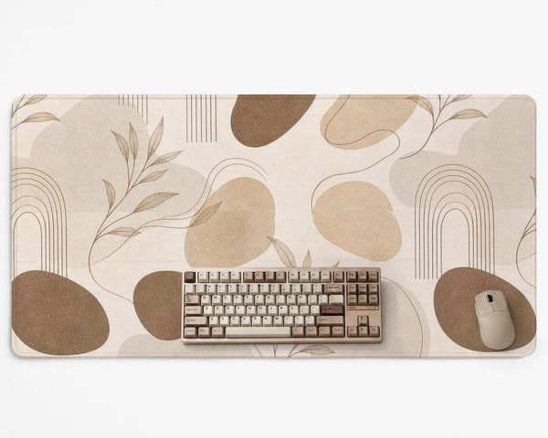 Beige desk mat with fine botanical line drawings and soft abstract shapes on a light neutral background.
