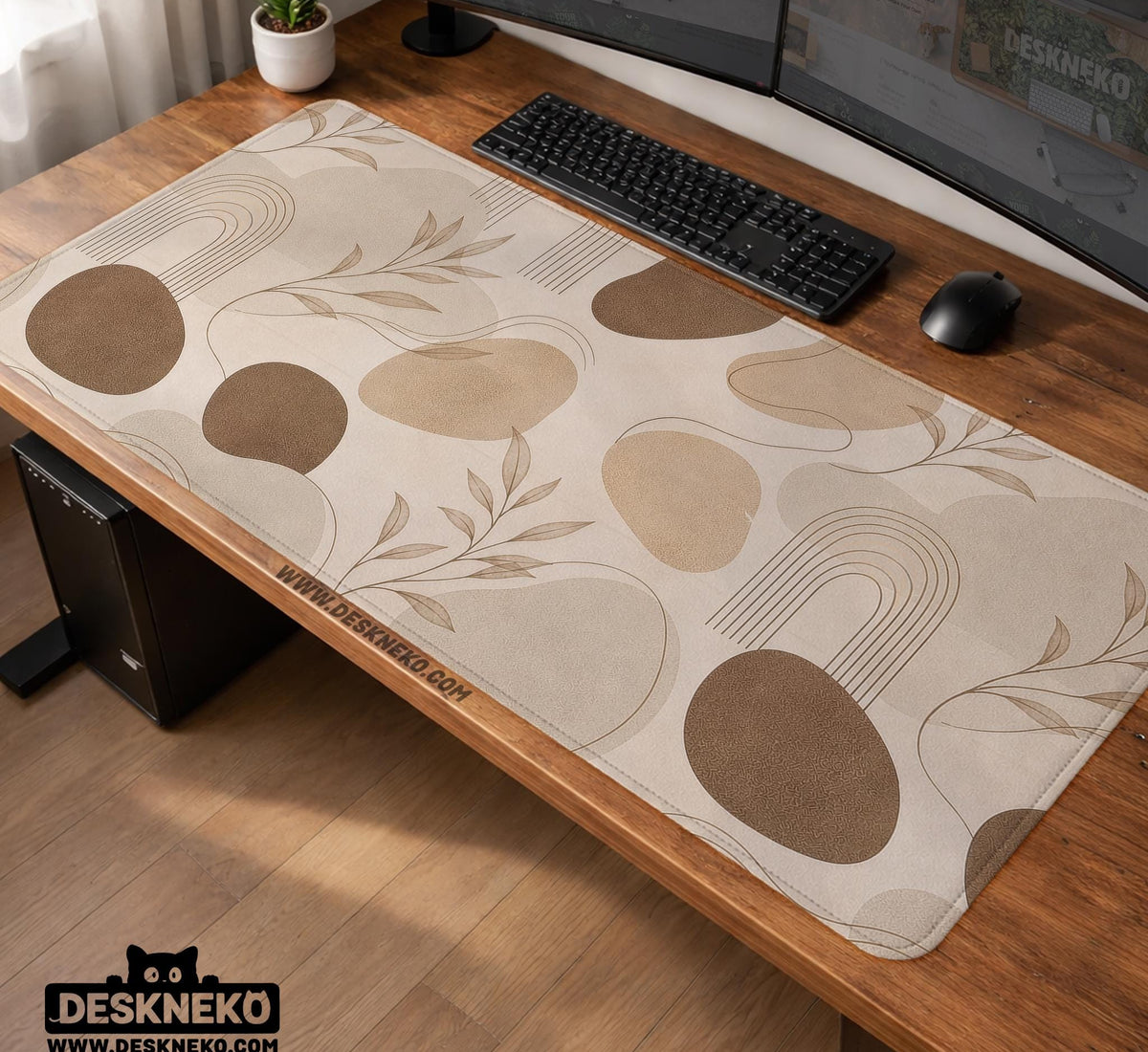 Beige desk mat with fine botanical line drawings and soft abstract shapes on a light neutral background.