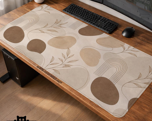 Beige desk mat with fine botanical line drawings and soft abstract shapes on a light neutral background.