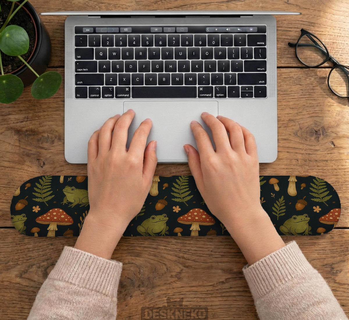 Dark botanical desk mat options with frogs, mushrooms, ferns, and acorns in brown and green tones, plus a matching keyboard wrist rest.