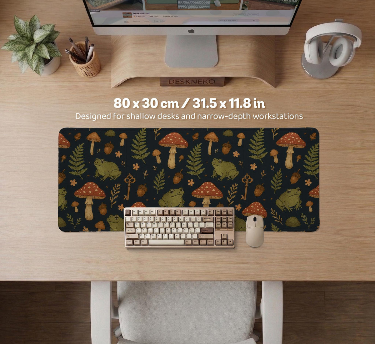 Dark forest-themed desk mat with an all-over pattern of frogs, mushrooms, fern leaves, acorns, tiny flowers, and antique keys.