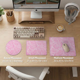 Pastel pink desk mat with a marble-style design, white flowing lines, and small sparkle accents.