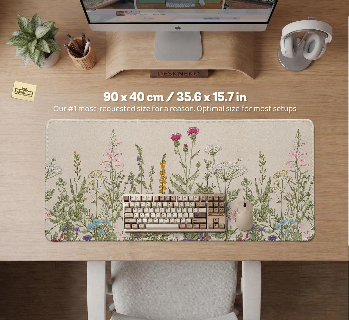 A desk mat with a botanical meadow design featuring wildflowers, leafy stems, and soft neutral colors.