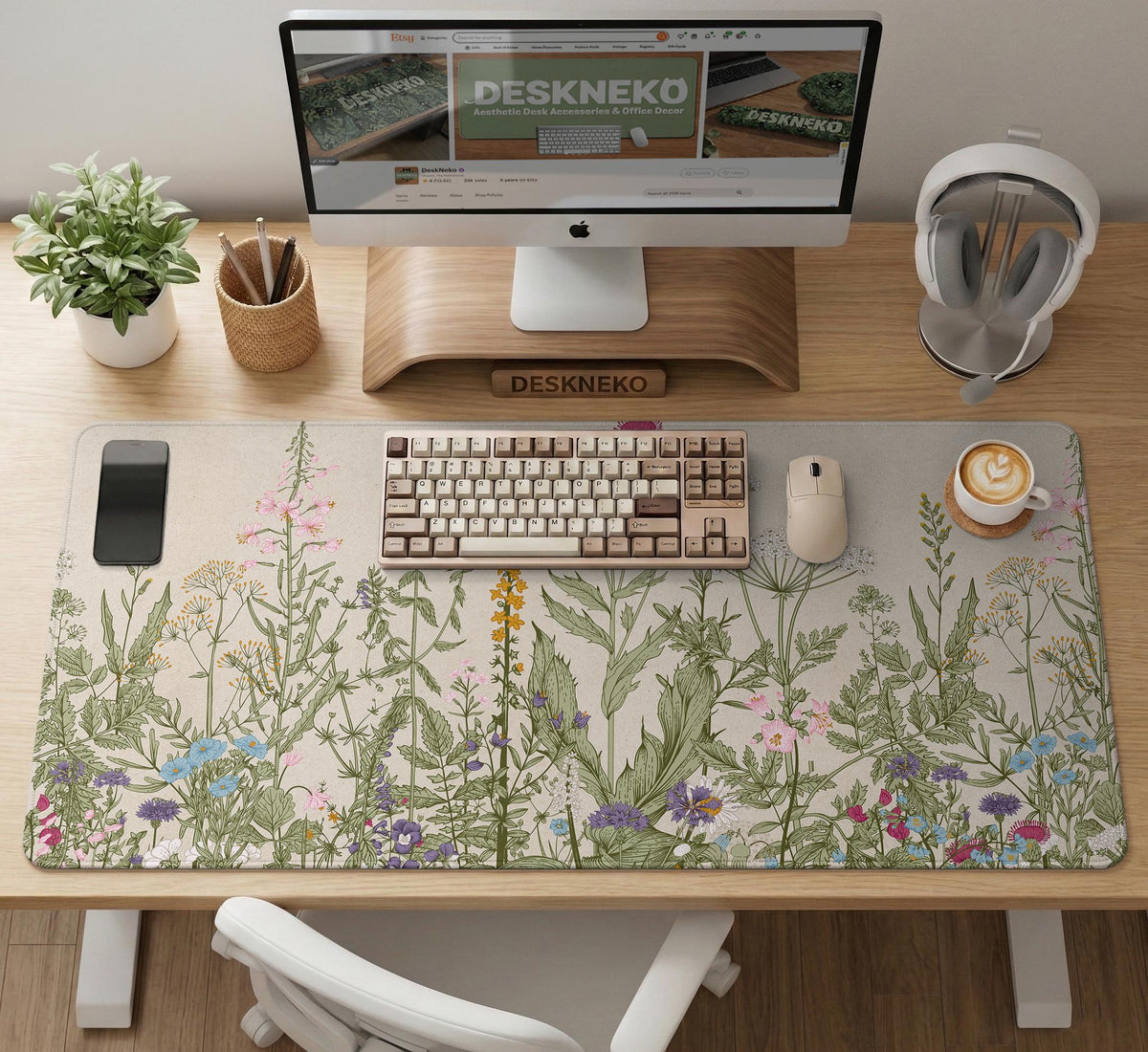 A desk mat with a botanical meadow design featuring wildflowers, leafy stems, and soft neutral colors.