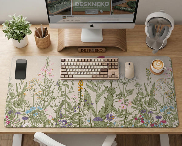 A desk mat with a botanical meadow design featuring wildflowers, leafy stems, and soft neutral colors.