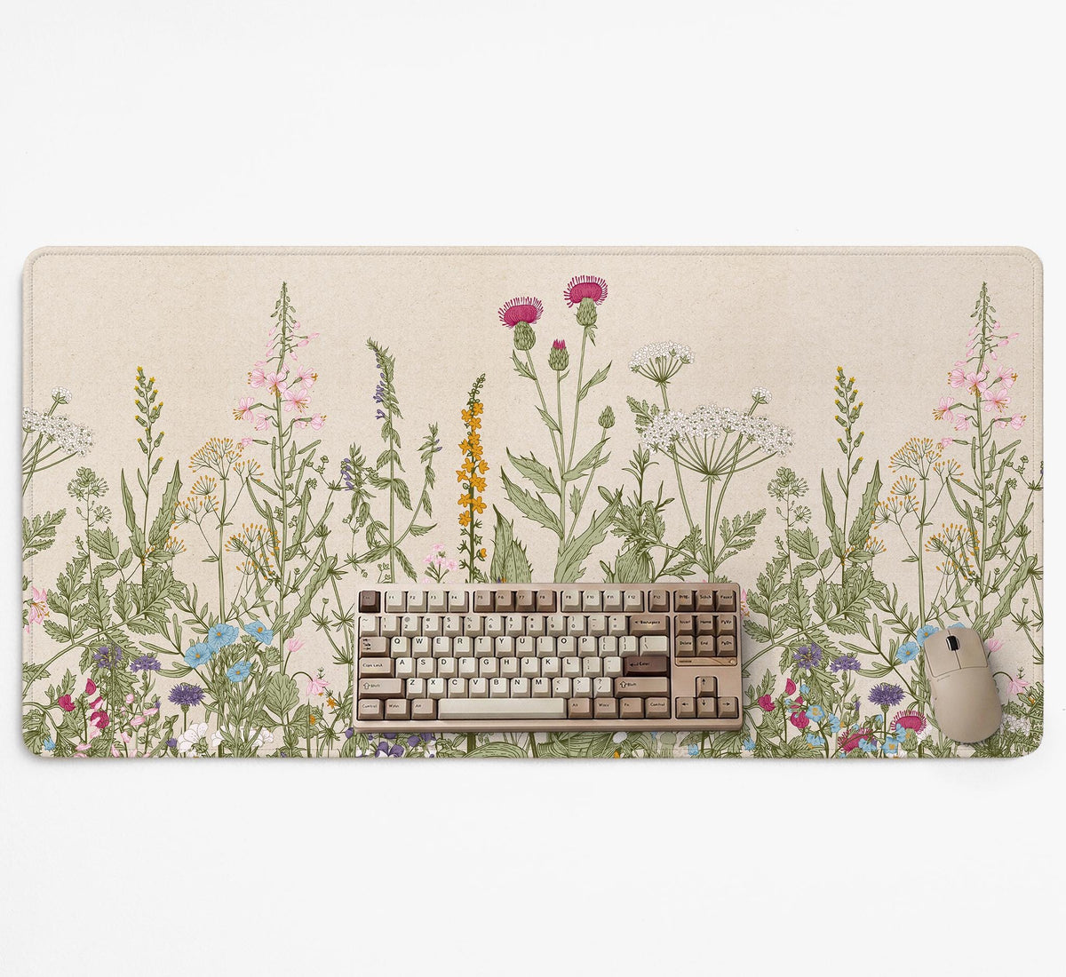 A desk mat with a botanical meadow design featuring wildflowers, leafy stems, and soft neutral colors.