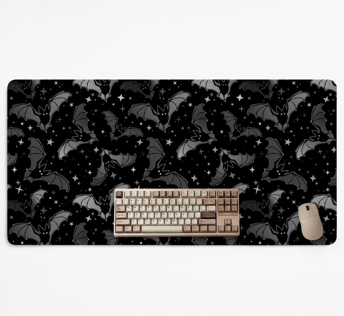 Black desk mat with a dark bat pattern and scattered stars on a charcoal background.