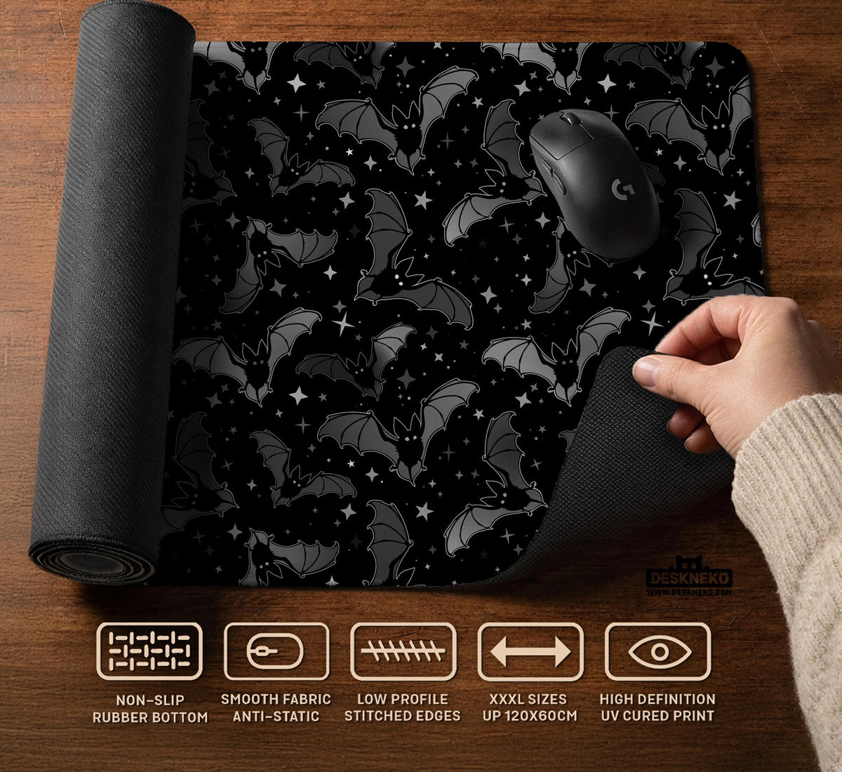 Black desk mat with a dark bat pattern and scattered stars on a charcoal background.
