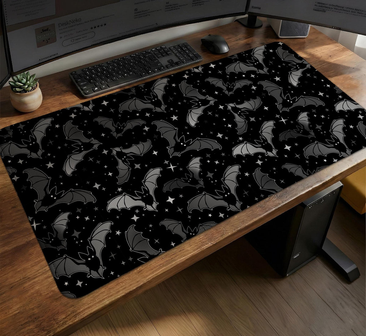 Black desk mat with a dark bat pattern and scattered stars on a charcoal background.