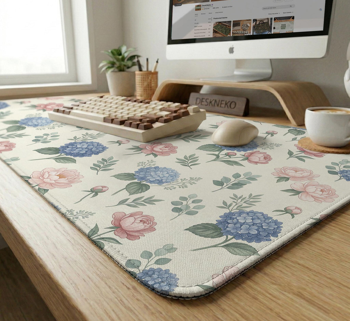 Floral desk mat with sage greenery, pink peonies, blue flowers, and a warm cream background.