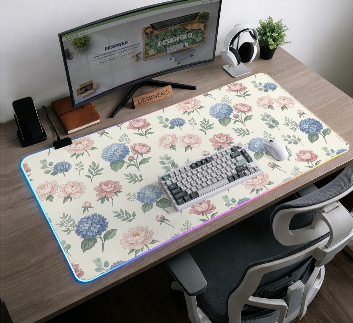 Floral desk mat with sage greenery, pink peonies, blue flowers, and a warm cream background.