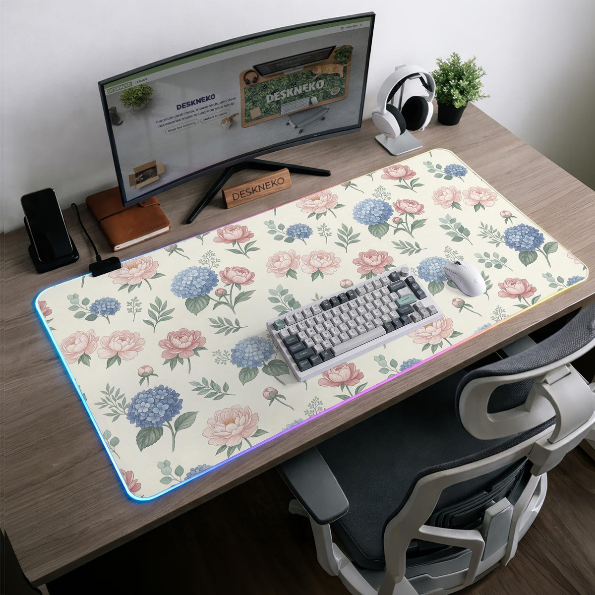 Floral desk mat with sage greenery, pink peonies, blue flowers, and a warm cream background.
