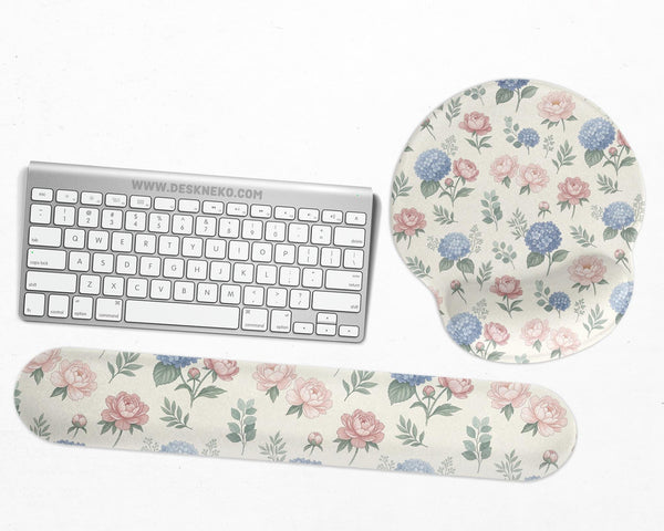 Mousepad and keyboard wrist rest with a floral print of blue hydrangeas, pink peonies, sage leaves, and a cream background.