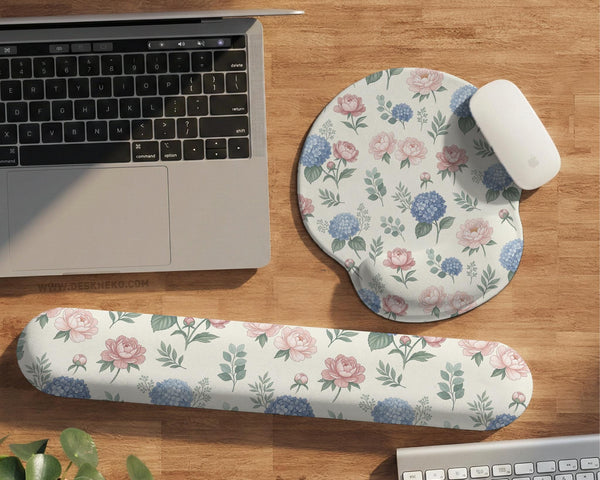 Mousepad and keyboard wrist rest with a floral print of blue hydrangeas, pink peonies, sage leaves, and a cream background.