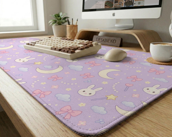 Pastel lavender desk mat with an all-over pattern of bunnies, crescent moons, clouds, bows, stars, and small flowers.