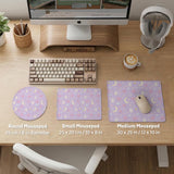 Lavender desk mat with an all-over pattern of bunny faces, clouds, moons, bows, and flowers in pastel colors.