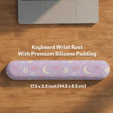 Lavender desk mat with an all-over pattern of bunny faces, clouds, moons, bows, and flowers in pastel colors.