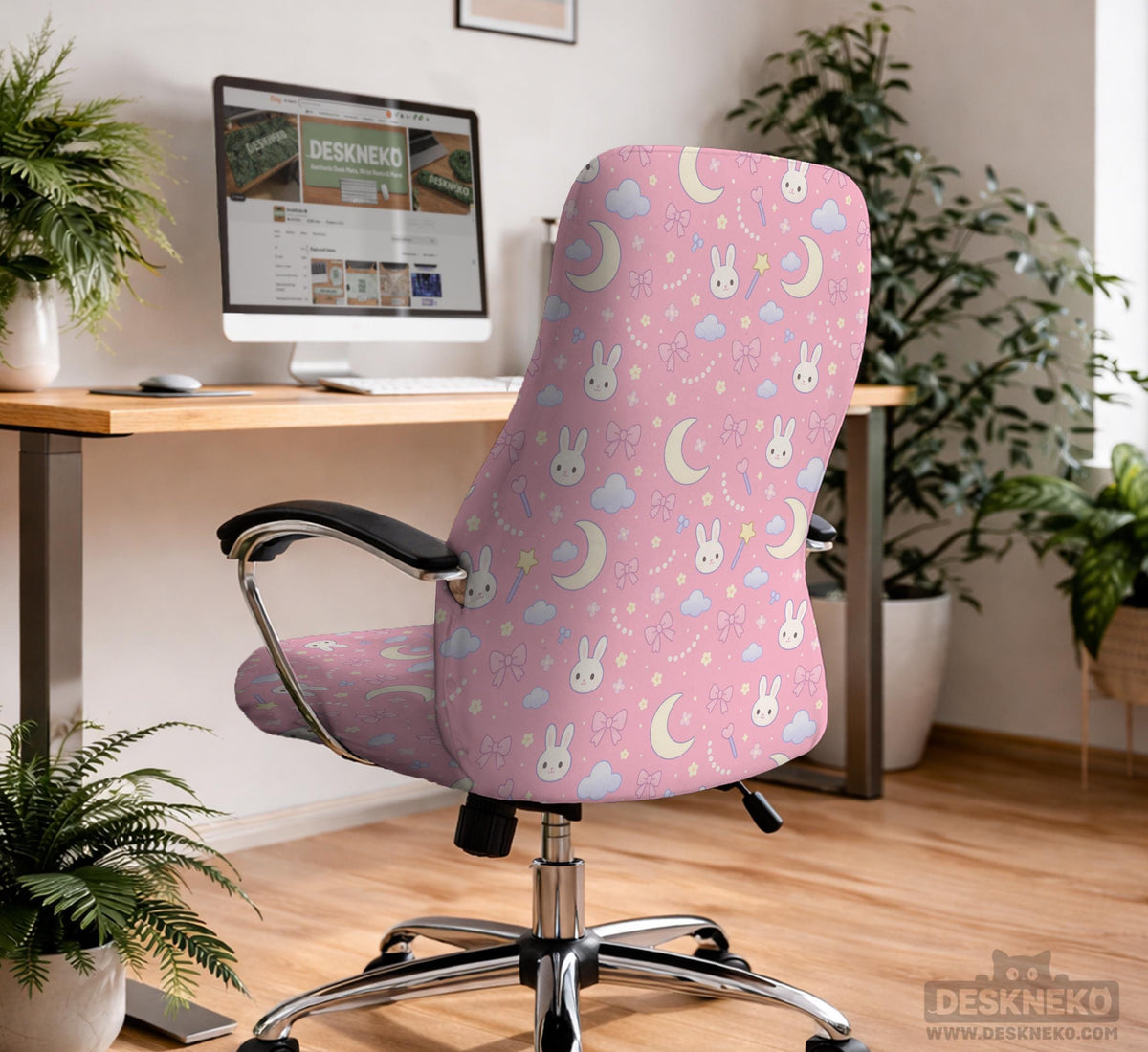 Pink chair cover with bunny faces, crescent moons, clouds, and bows on a white chair.