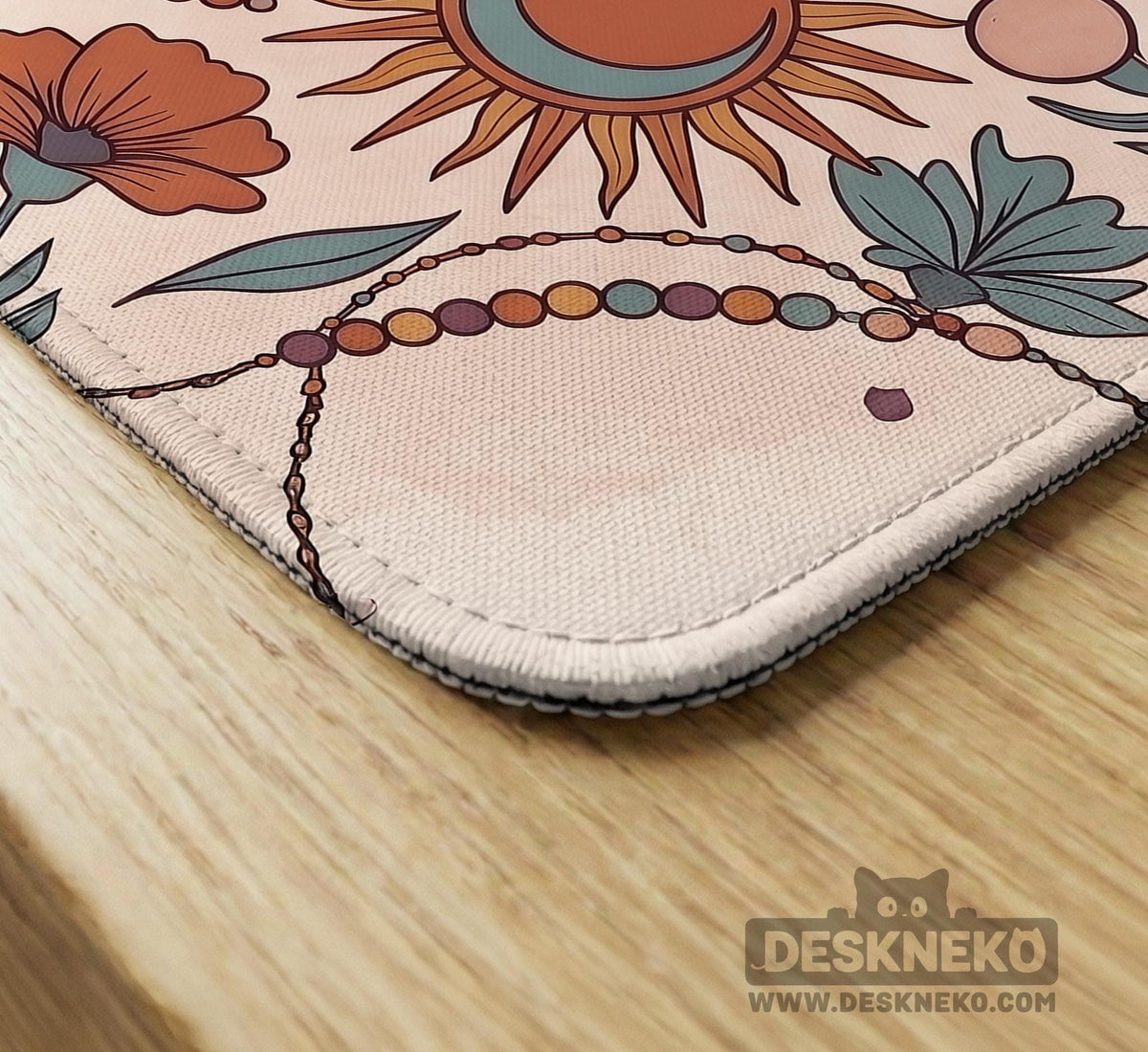 A square mahjong mat with a scalloped edge, sun and moon artwork, terracotta flowers, a soft cream background, and a decorative border around the play area.