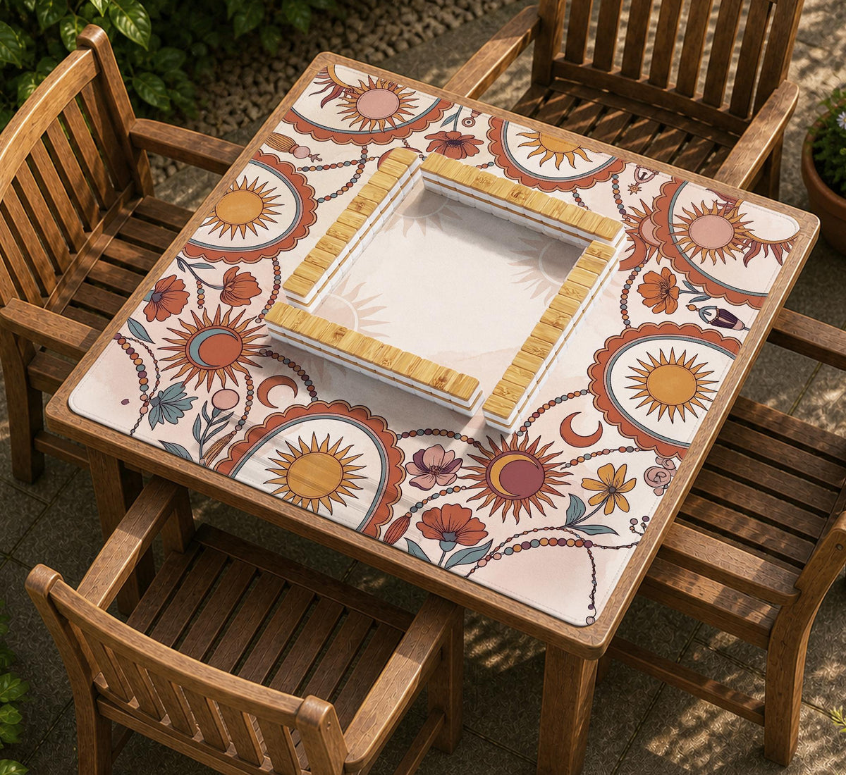 A square mahjong mat with a scalloped edge, sun and moon artwork, terracotta flowers, a soft cream background, and a decorative border around the play area.