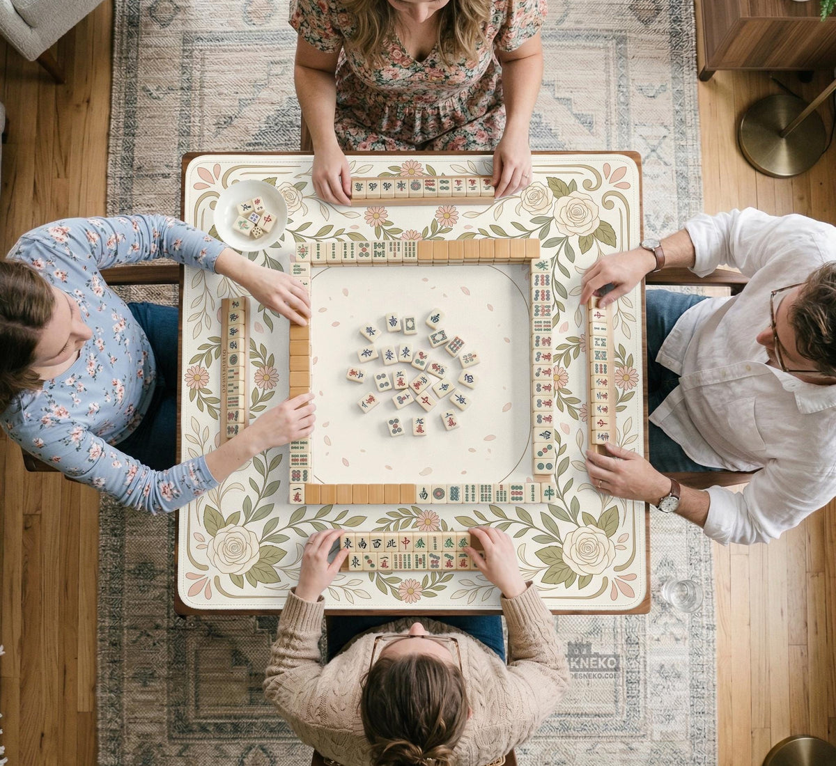 Square mahjong mat with a light floral border in sage green, cream, and blush around a plain center play area.