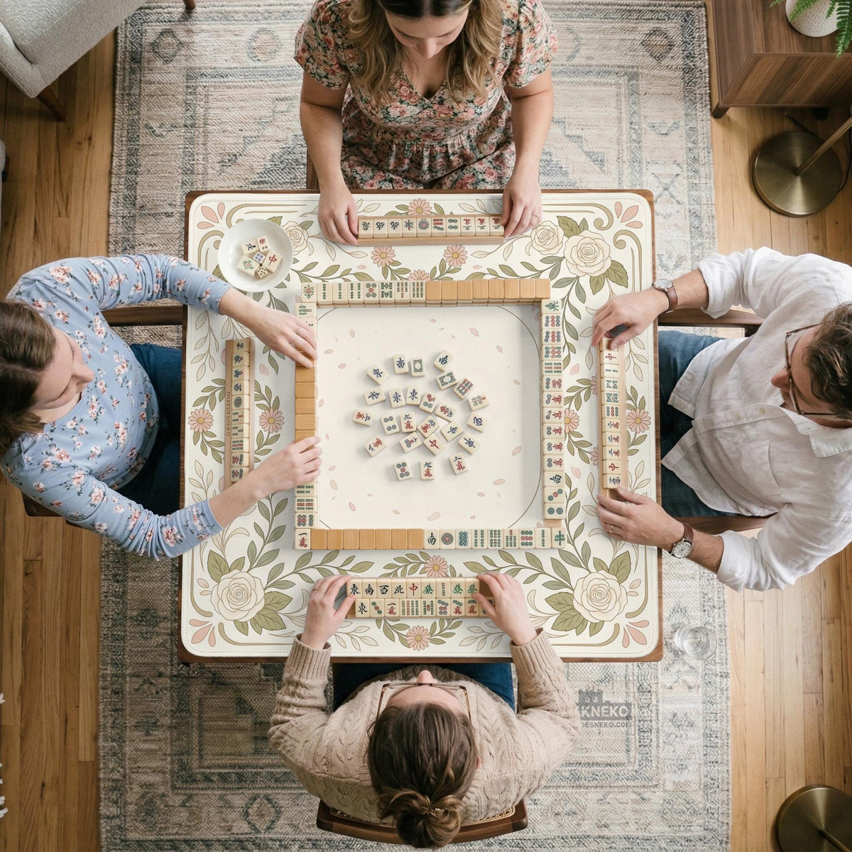 Square mahjong mat with a light floral border in sage green, cream, and blush around a plain center play area.