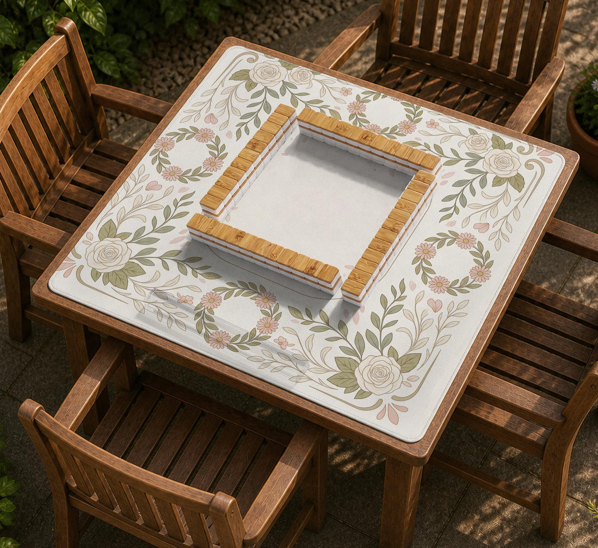 Square mahjong mat with a light floral border in sage green, cream, and blush around a plain center play area.