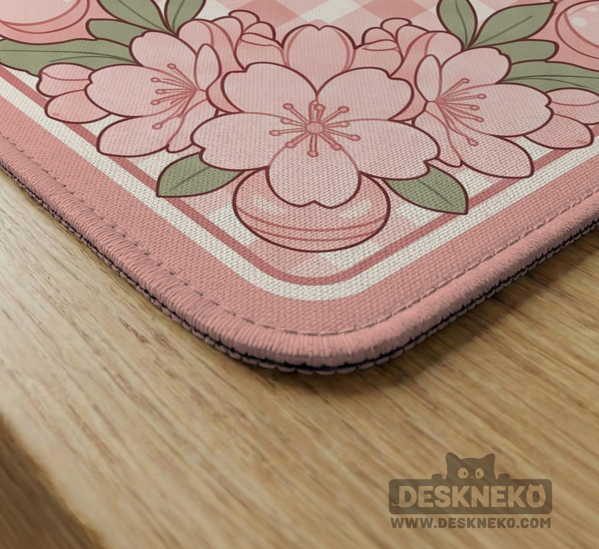 Pink gingham mahjong mat with a floral border, cherry blossom details, and a bow design around a plain center play area.