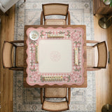 Pink gingham mahjong mat with a floral border, cherry blossom details, and a bow design around a plain center play area.