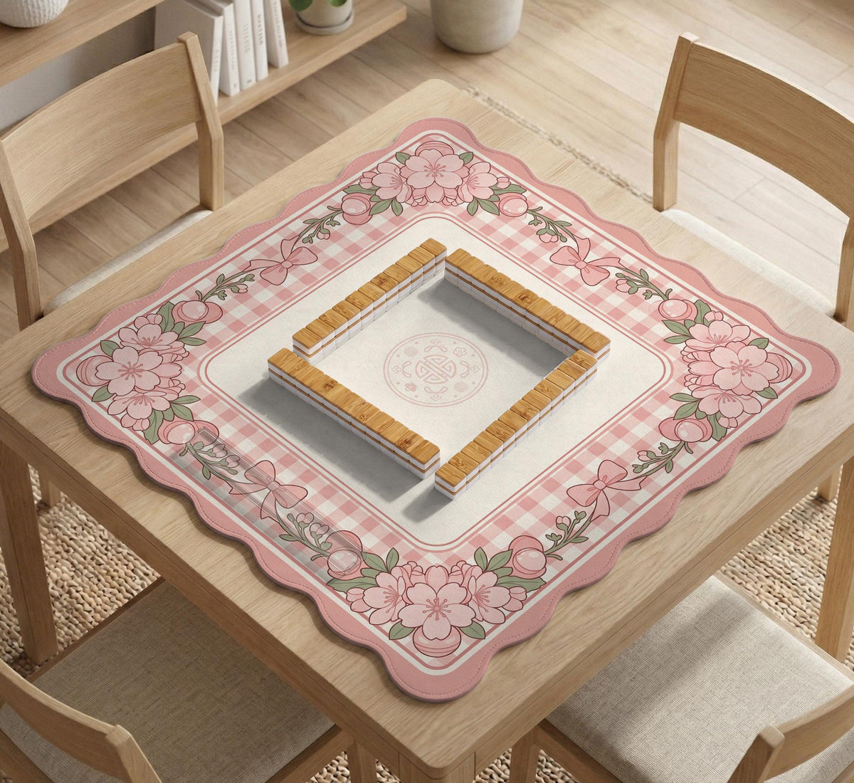 Pink gingham mahjong mat with a floral border, cherry blossom details, and a bow design around a plain center play area.