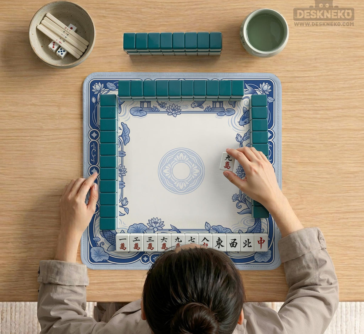 Blue and white square mahjong mat with a koi fish and lotus border design and a plain center area.