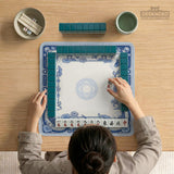 Navy blue square mahjong table mat with lotus flowers and koi fish in a porcelain-style border and a plain center.
