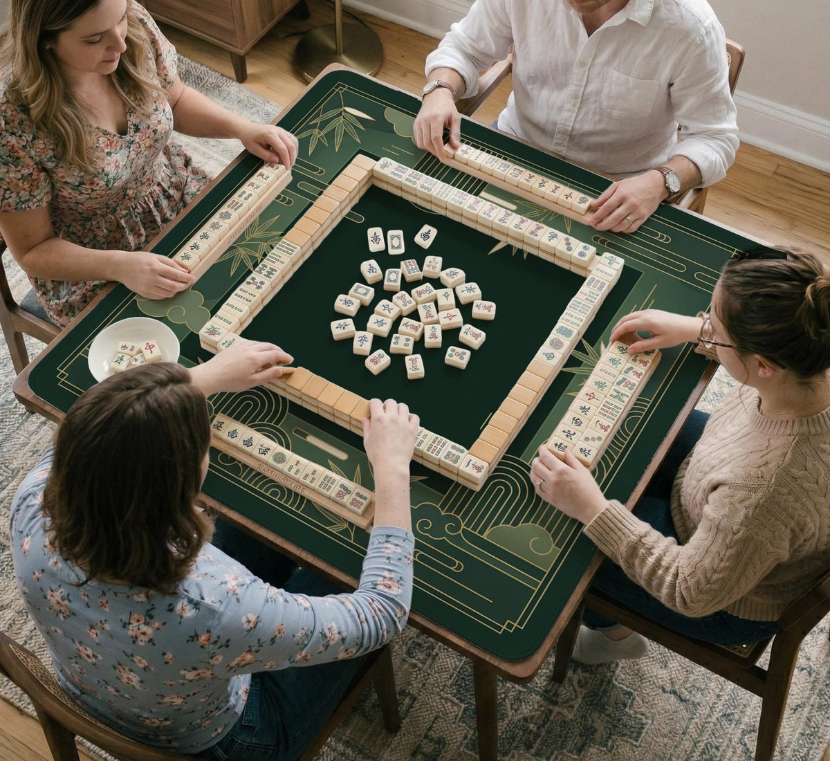 Square emerald green mahjong mat with bamboo line art, gold geometric cloud shapes, and a plain center playing area.