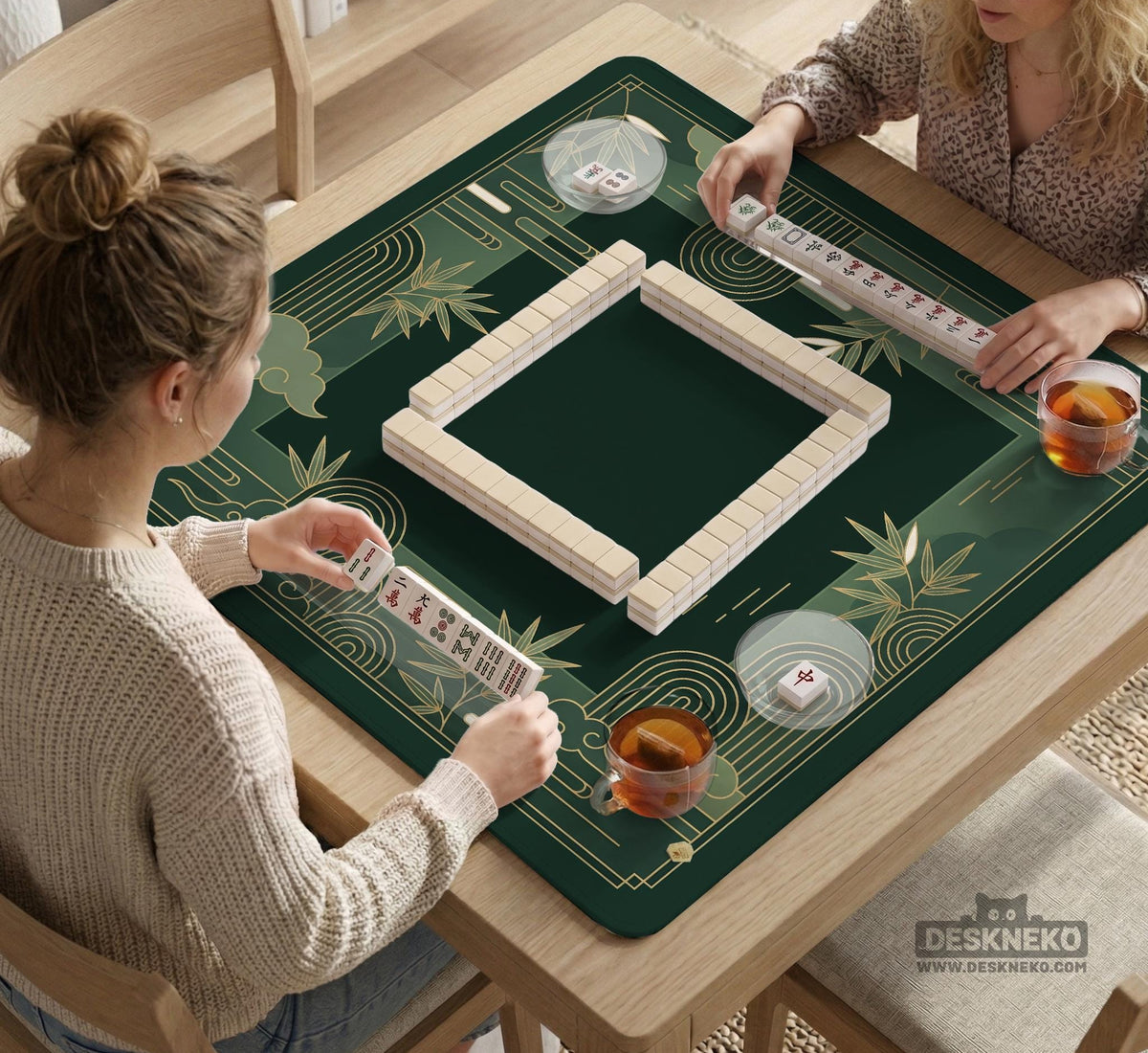 Square emerald green mahjong mat with bamboo line art, gold geometric cloud shapes, and a plain center playing area.