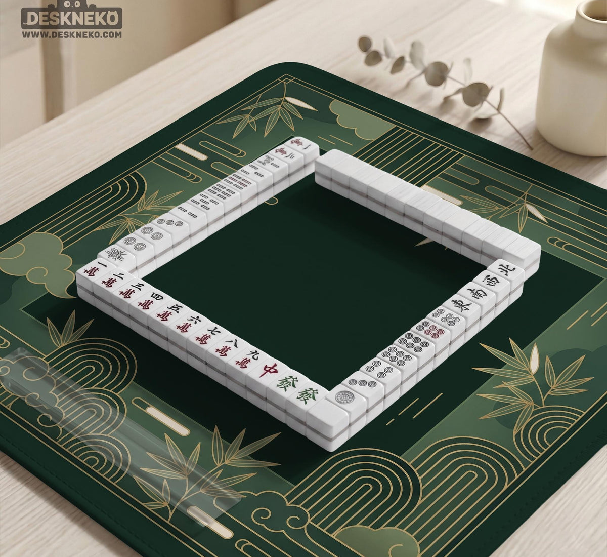 Square emerald green mahjong mat with bamboo line art, gold geometric cloud shapes, and a plain center playing area.