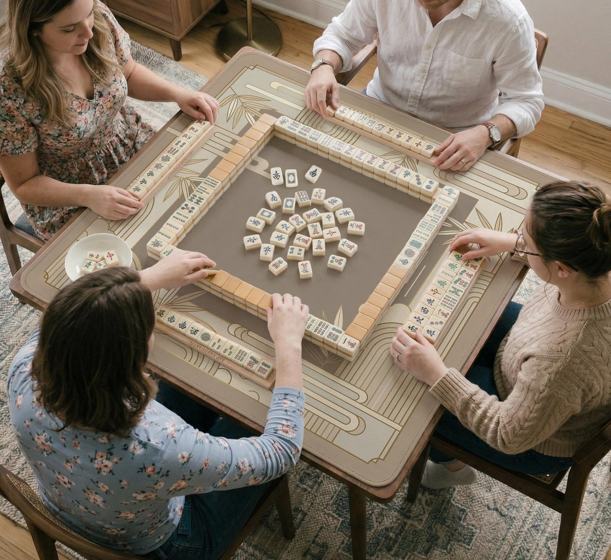 Beige and gold square mahjong mat with a bamboo pattern and geometric border.