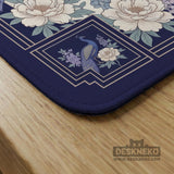 Blue mahjong mat with a floral peacock border and an open center area for tile play.