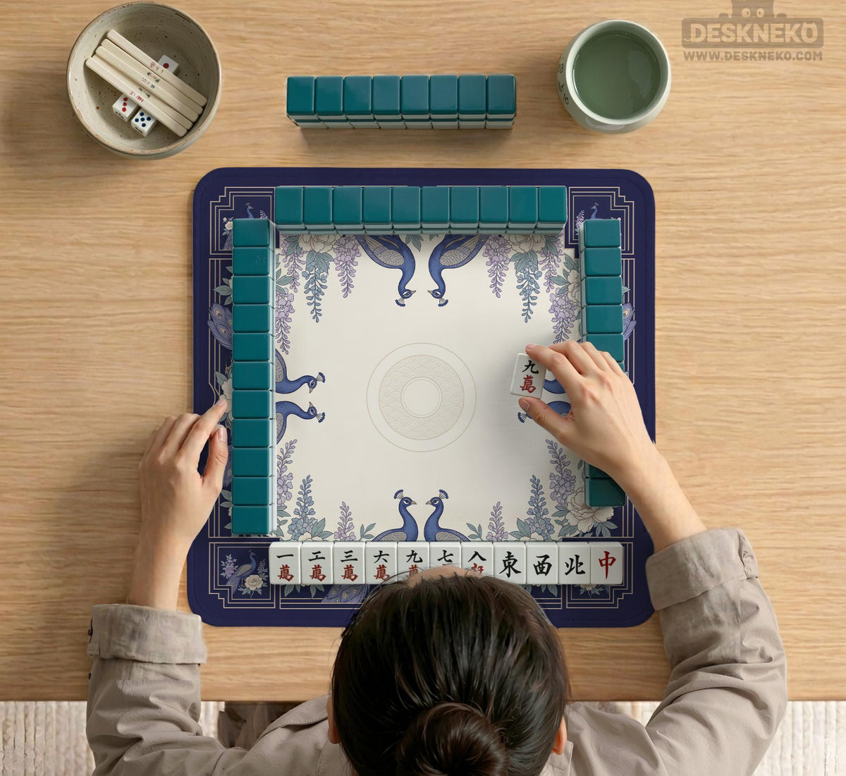 Blue mahjong mat with a floral peacock border and an open center area for tile play.