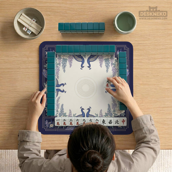 Blue mahjong mat with a floral peacock border and an open center area for tile play.